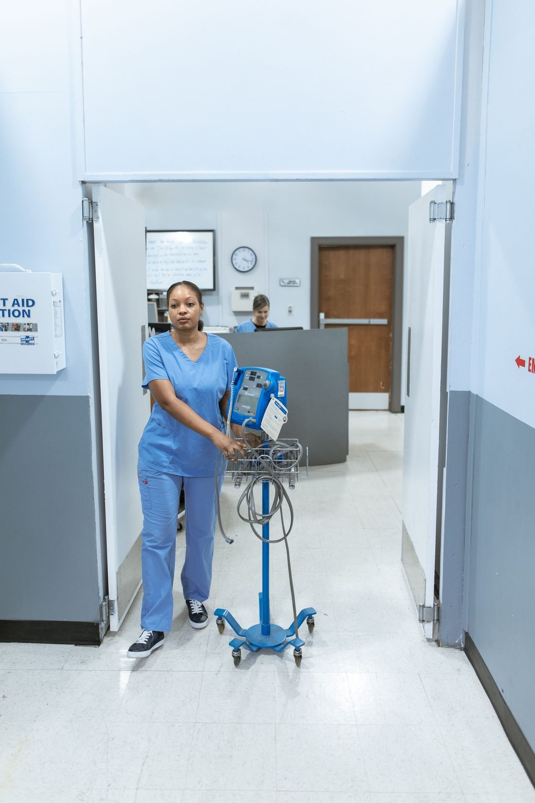 A nurse moving monitoring equipment through the ward
